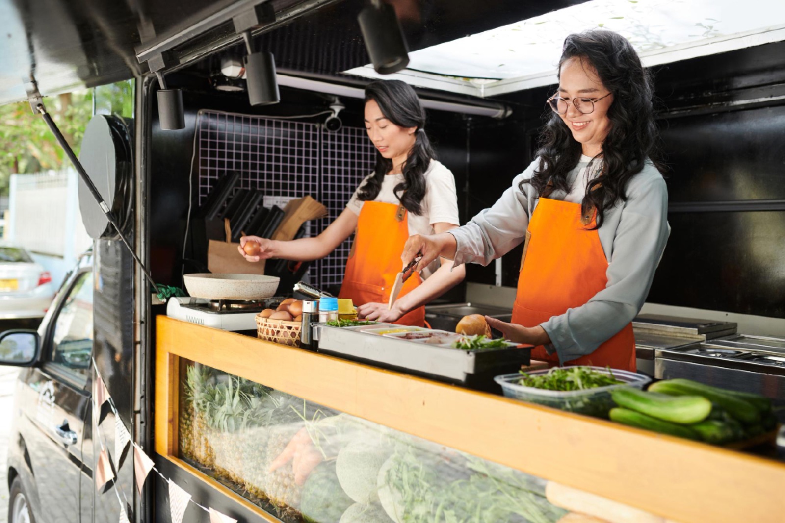 Staff preparing food inside a Bistro catering trailer