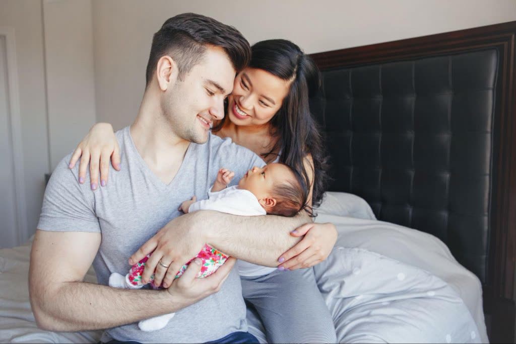 Couple holding their newborn baby after successful fertility treatment