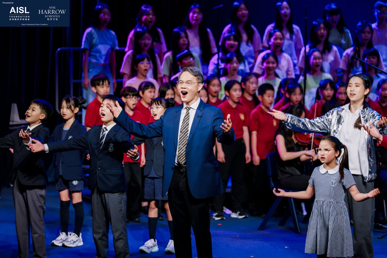 Harrow students performing in a school musical on stage