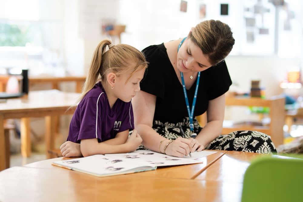 Magic Years teacher working one-on-one with a young student in class