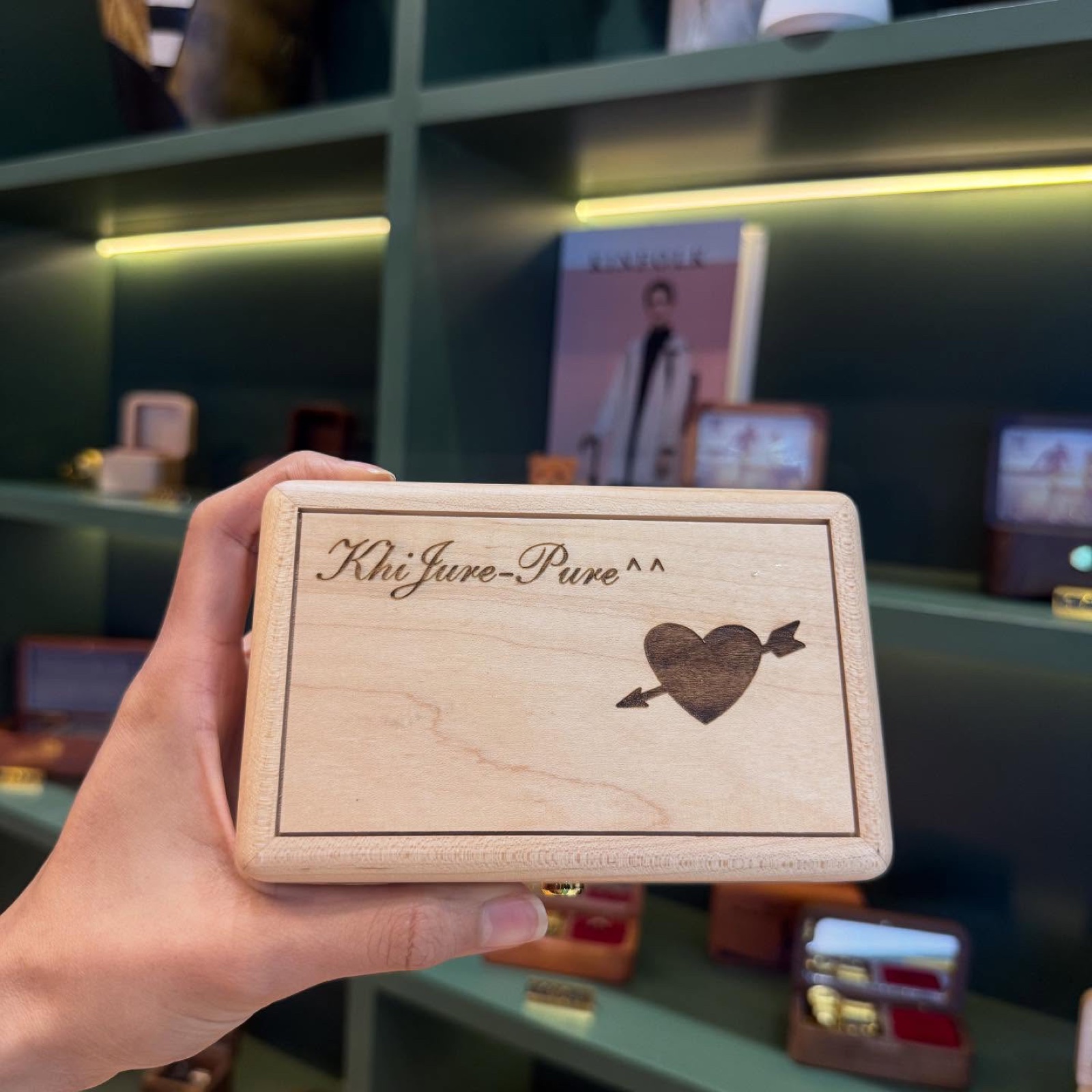 A personalised engraved wooden music box held in hand