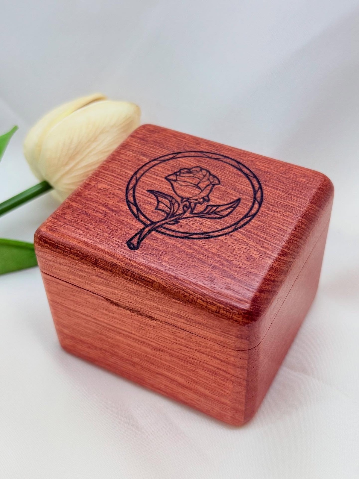 A wooden music box engraved with a rose design