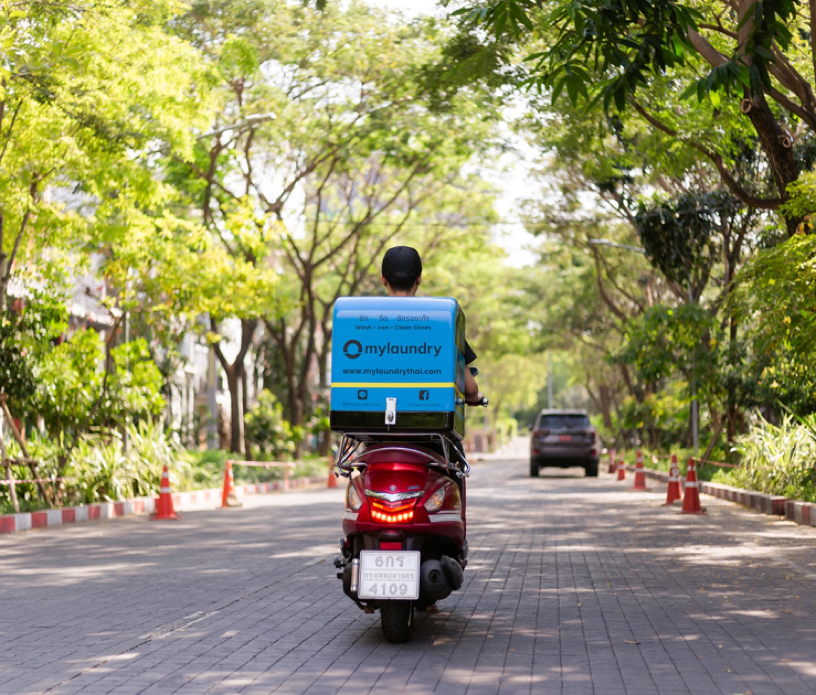 A mylaundry delivery rider on a scooter