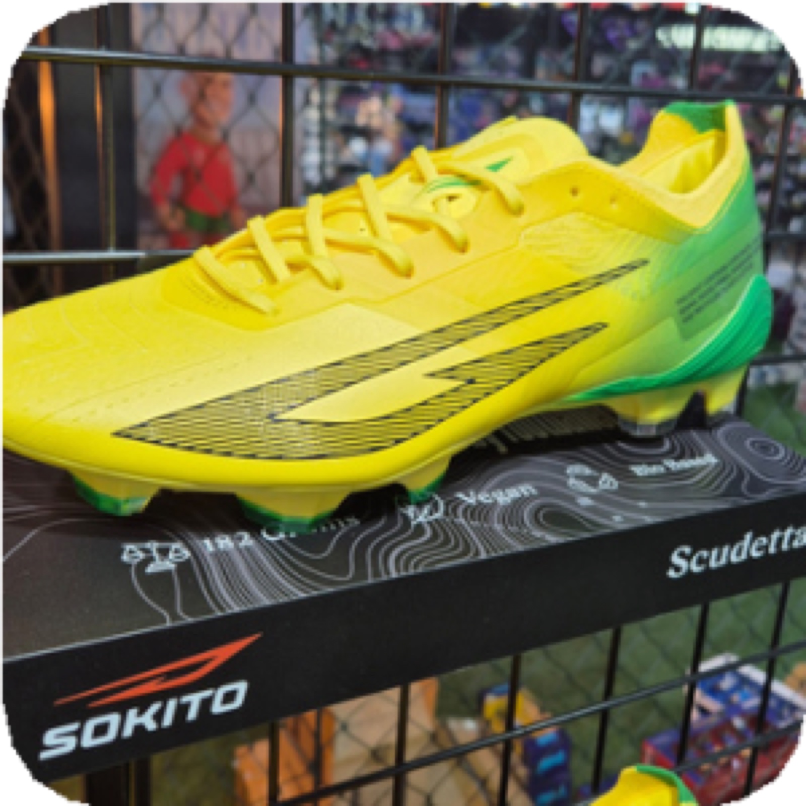 A yellow Sokito football boot on display