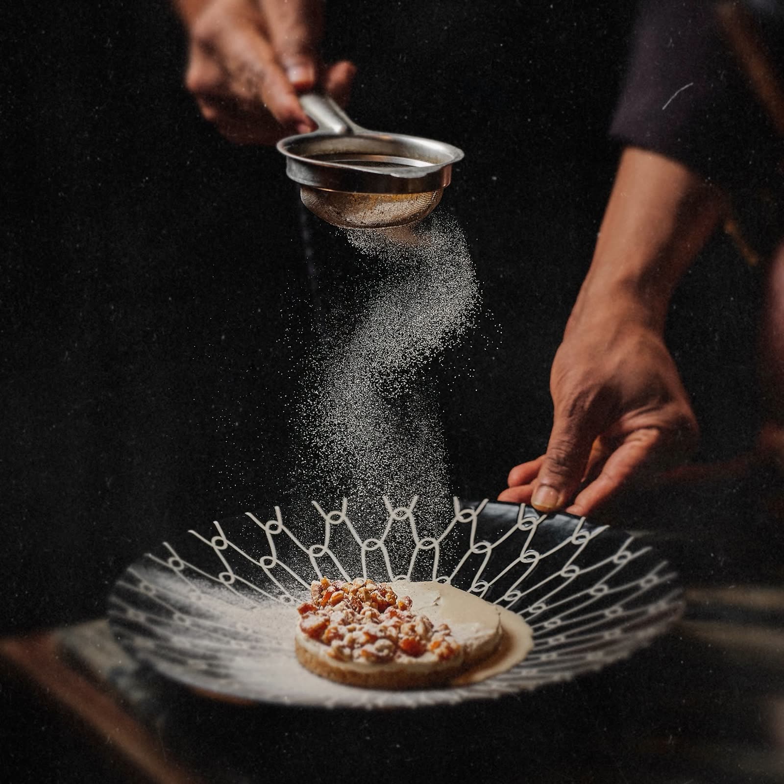 Punjab Grill chef dusting a plated dessert