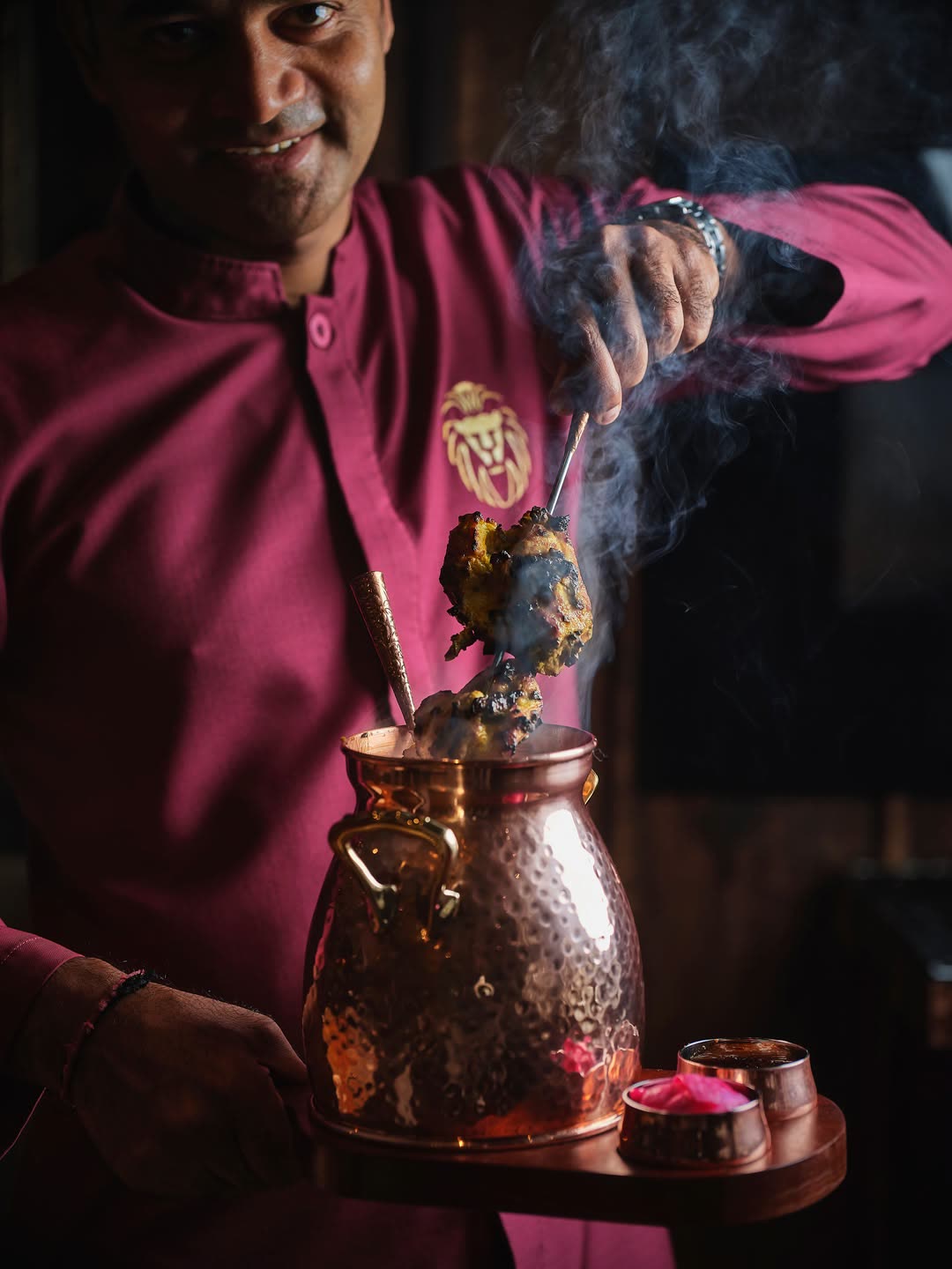 Punjab Grill waiter serving smoked tandoori from a copper pot