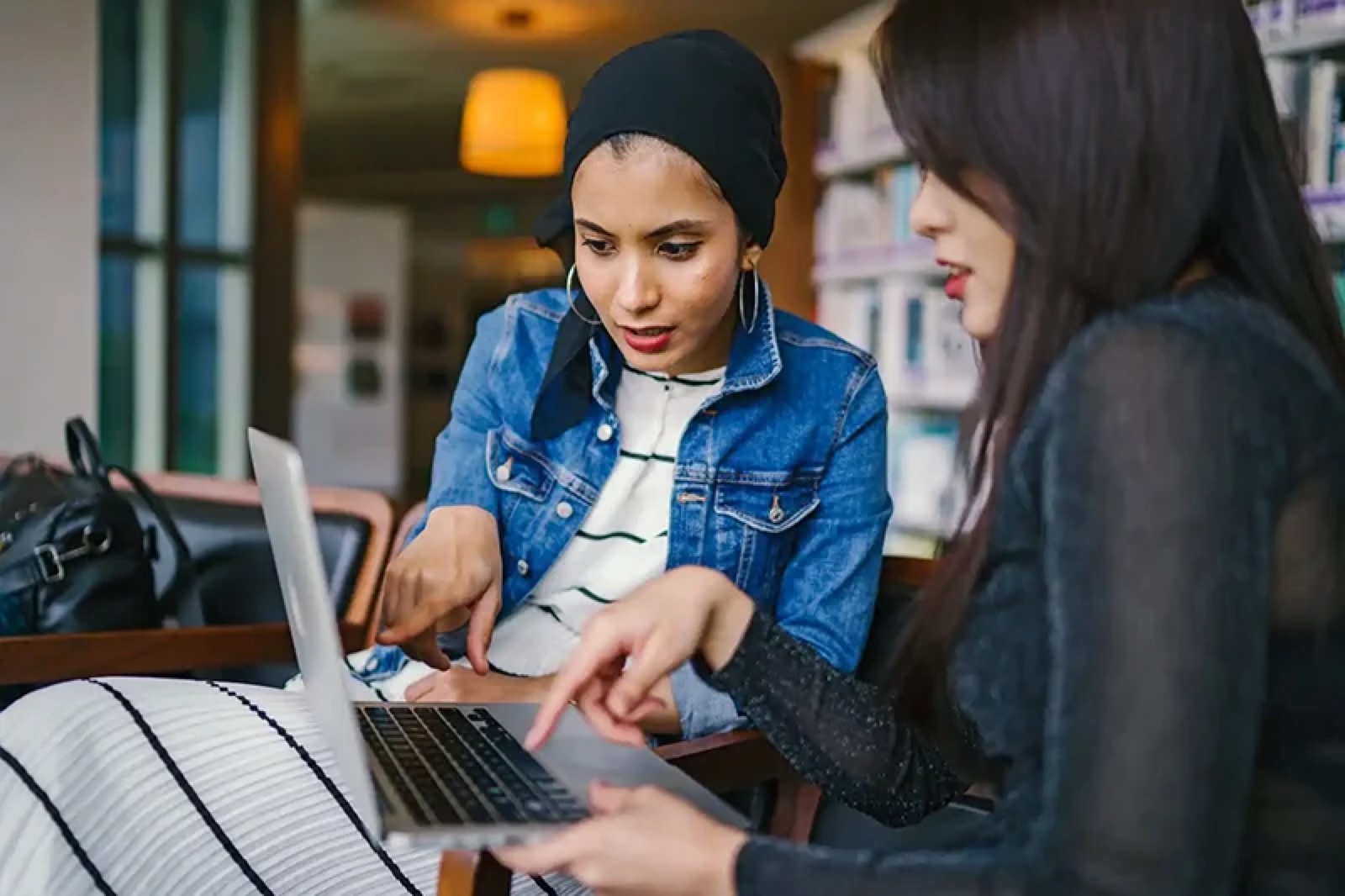 Two colleagues reviewing sourcing options on a laptop