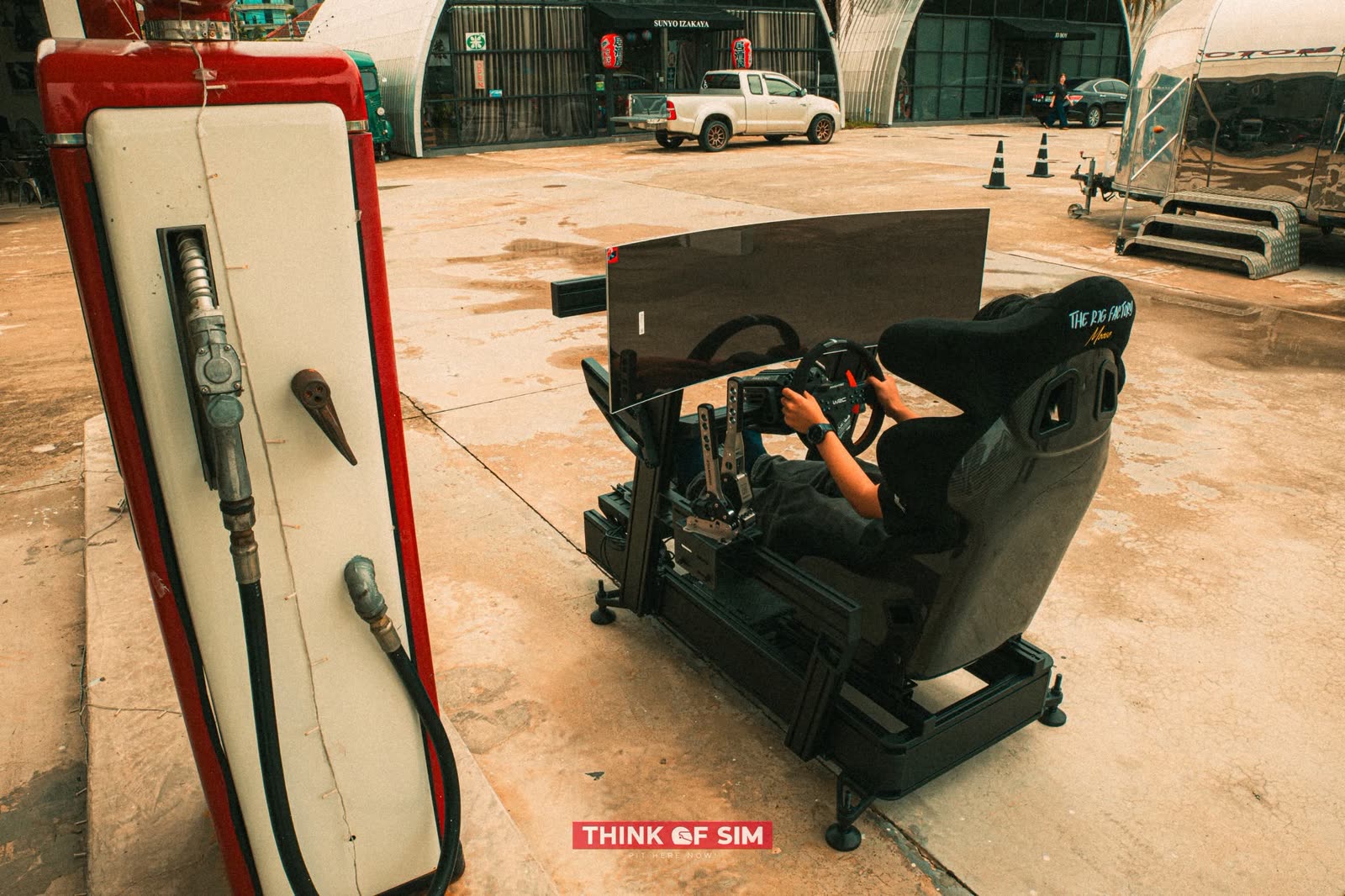 Racing simulator beside a vintage fuel pump on a Think of Sim brand shoot