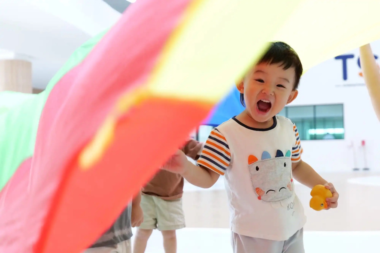 A young TSI International School student with a colourful craft project