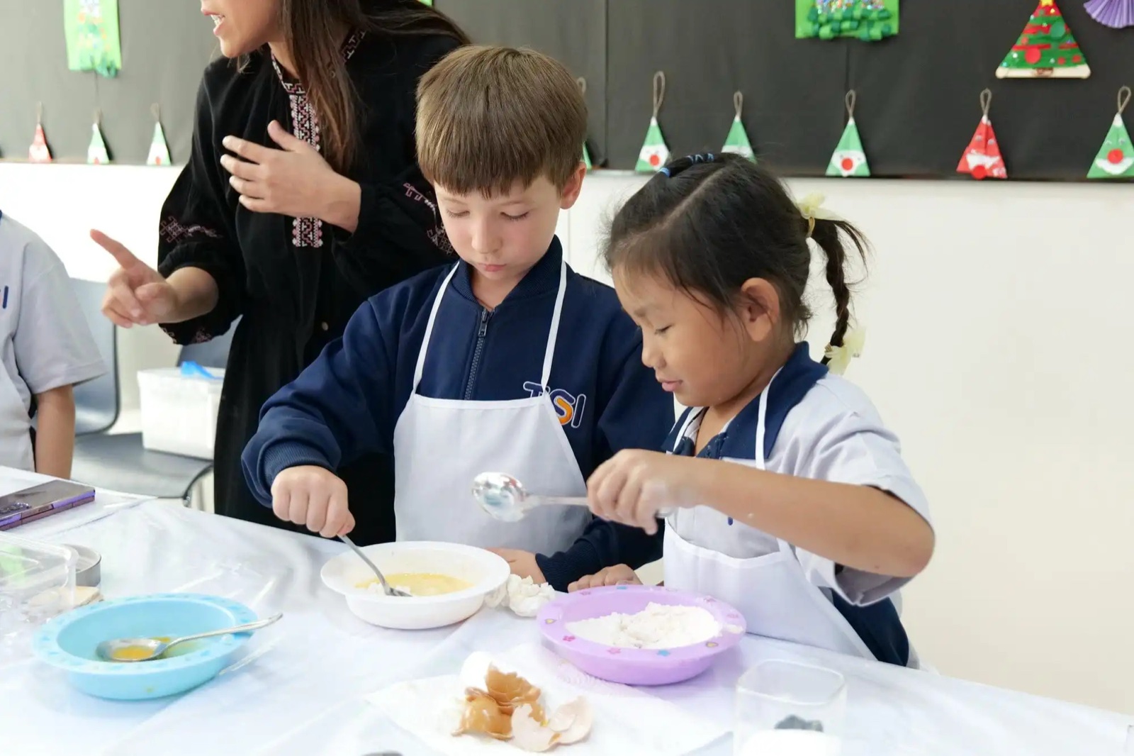 TSI International School students taking part in a cooking activity with a teacher