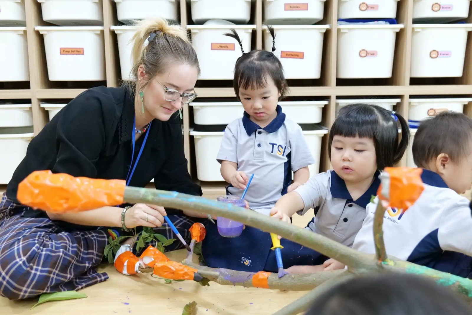 A TSI International School teacher leading an art activity with students
